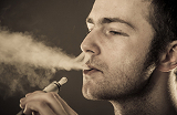 Un homme exhalant la fum&eacute;e d'une cigarette &eacute;lectronique
